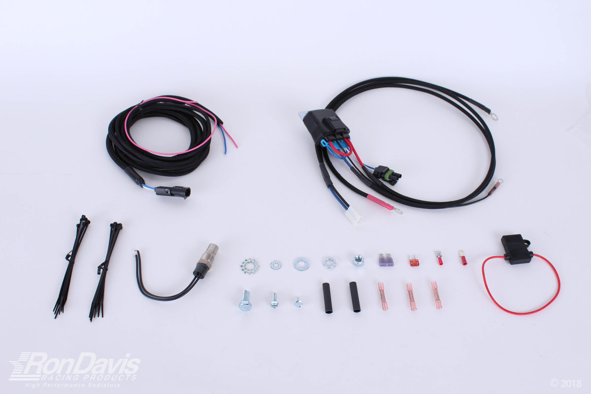An automotive wiring harness kit laid out on a white background, including a main black harness with multi-colored wires, a smaller black wire bundle, zip ties, a U-bend wire, mounting hardware, and a red wire connector. A RonDavis logo watermark is visible in the bottom-left corner.