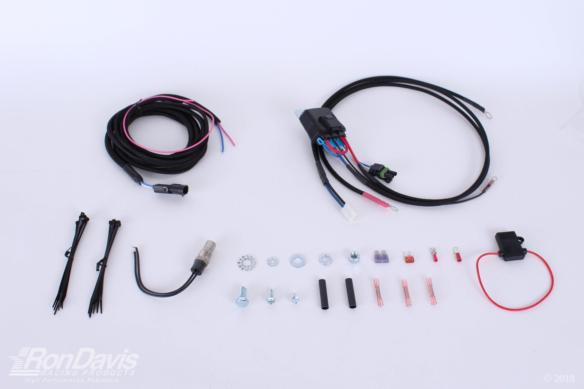 An automotive wiring harness kit laid out on a white background, including a main black harness with multi-colored wires, a smaller black wire bundle, zip ties, a U-bend wire, mounting hardware, and a red wire connector. A RonDavis logo watermark is visible in the bottom-left corner.