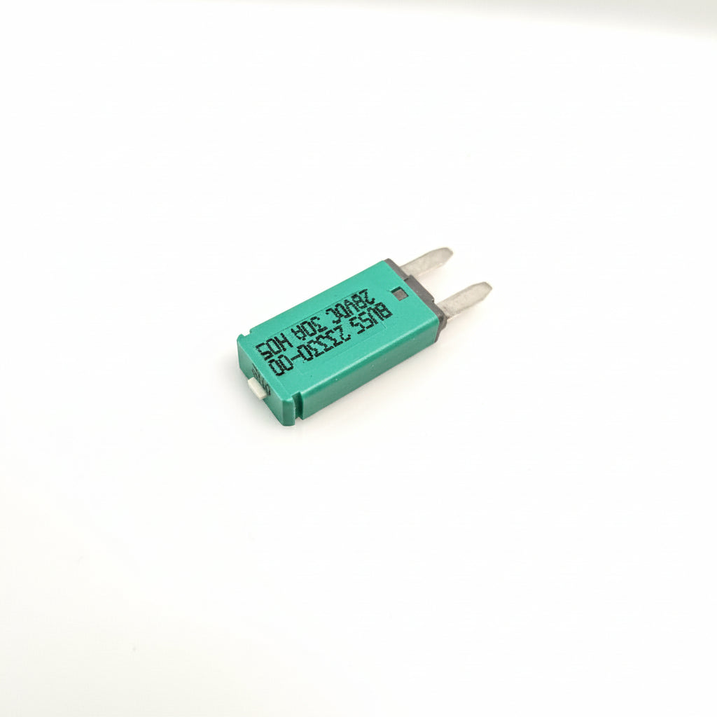 A small green electronic component breaker with two silver metal leads, featuring printed black text on its body, shown on a plain light background.